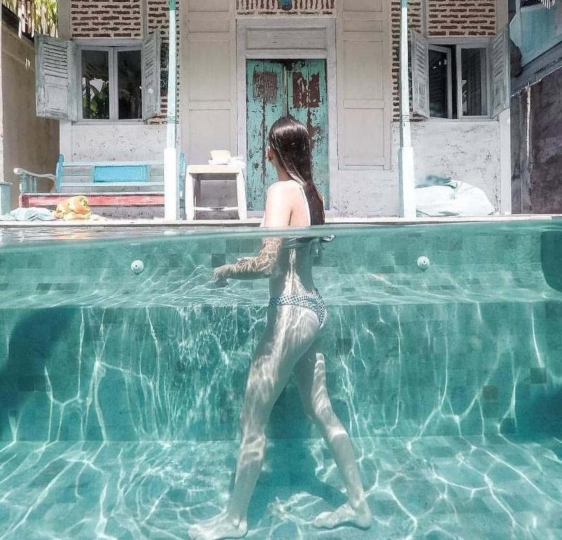 a woman standing in the water in a swimming pool at Hi Villa in Seminyak