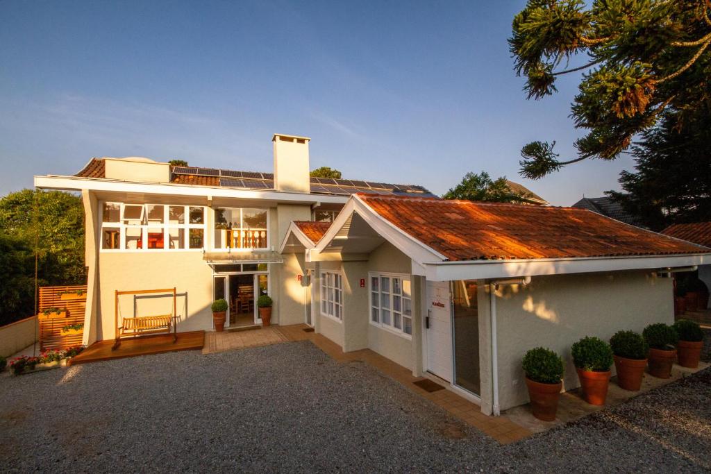 uma casa branca com um telhado vermelho em Casa Sabor Chocolate em Campos do Jordão