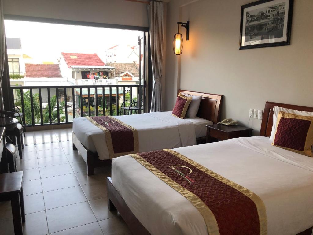 Postel nebo postele na pokoji v ubytování Sunshine Hoian Hotel