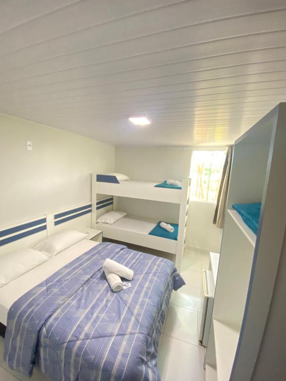 a bedroom with a bed and two bunk beds at Pousada Coração do Parque in Penha
