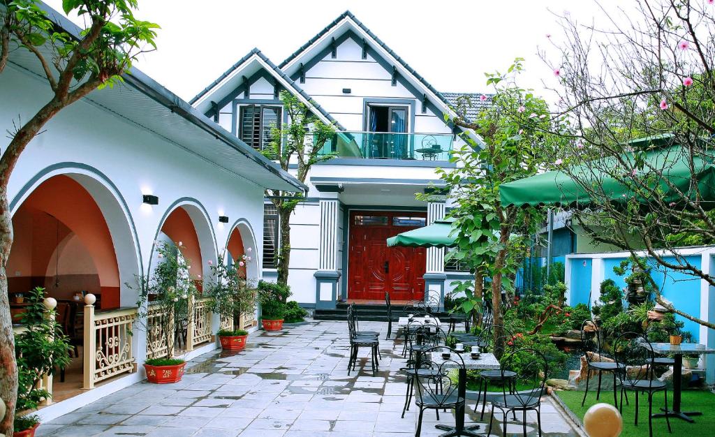 a patio with tables and chairs in front of a house at The Mountain View Homestay in Ninh Binh