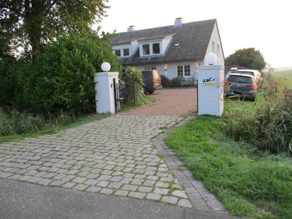 a house with a brick driveway in front of a house at Best Pension in Glückstadt