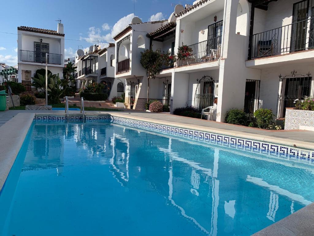 a swimming pool in front of some apartment buildings at Casa María in Nerja