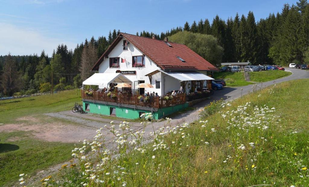 ein großes weißes Haus mit Balkon auf einem Feld in der Unterkunft Bergbaude Albrechts in Albrechts