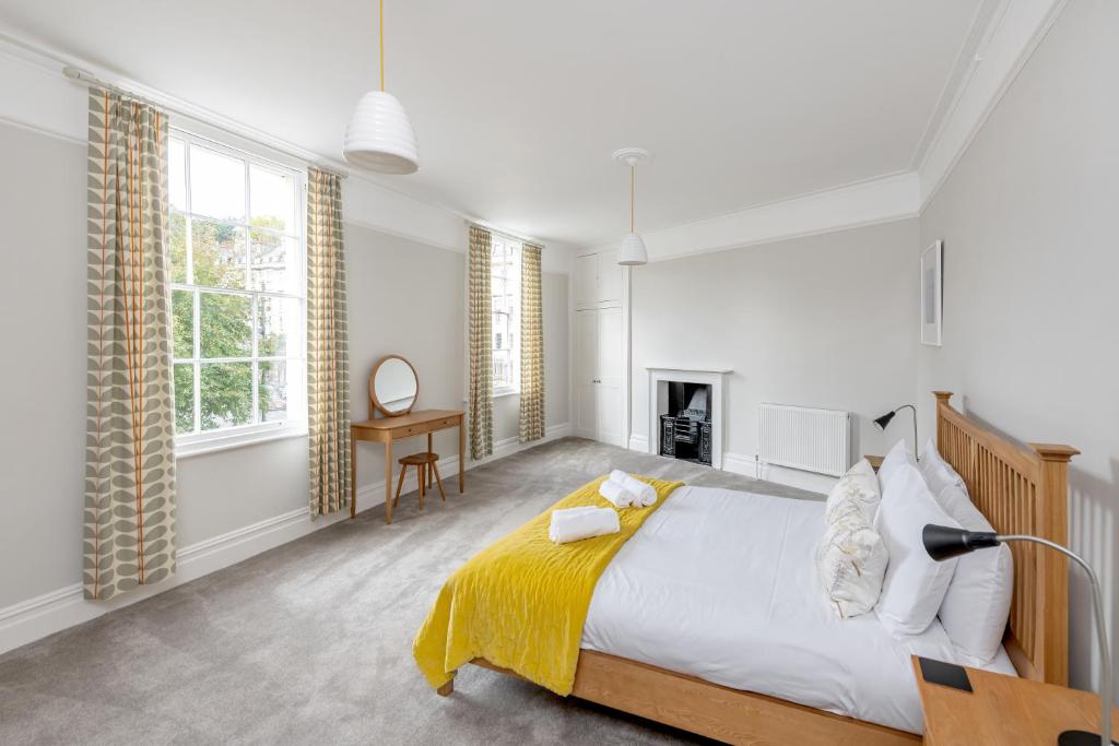 um quarto com uma cama grande e um cobertor amarelo em Spacious Maisonette with Parking - 10 mins walk from Bath Abbey - 2 Bed & 2 Bath em Bath