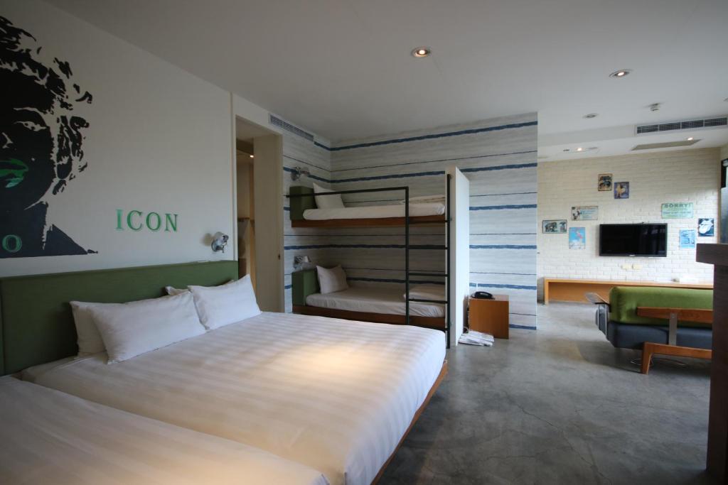 a bedroom with a large bed and a living room at Hotel Papa Whale-Kaohsiung Formosa Boulevard in Kaohsiung