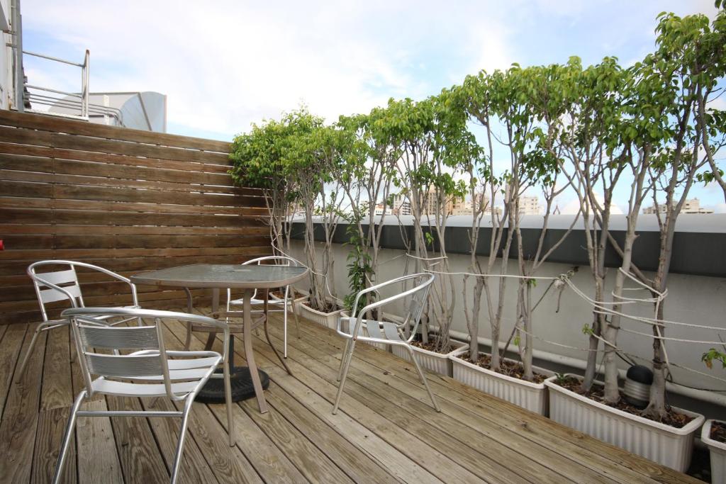 a table and chairs on a balcony with trees at Hotel Papa Whale-Kaohsiung Formosa Boulevard in Kaohsiung