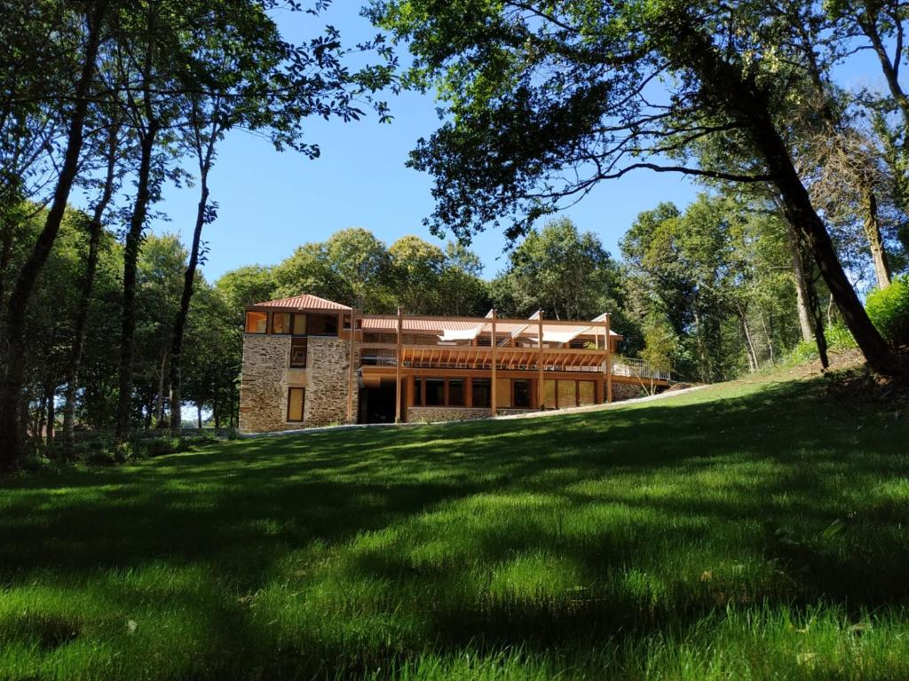 a house on a grassy hill with trees at Abeiro da loba 