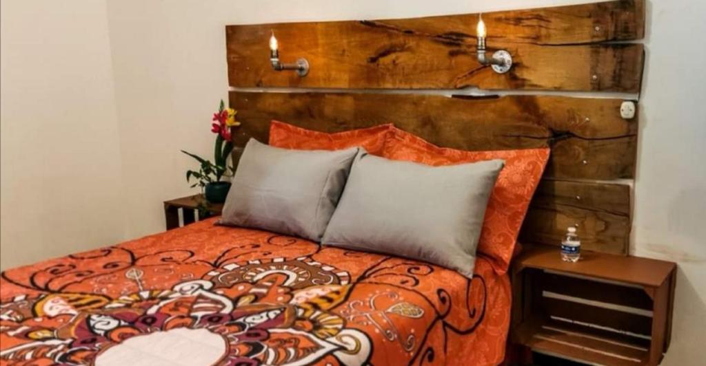 een slaapkamer met een bed met een houten hoofdeinde bij Casa Dahlia Querétaro in Querétaro