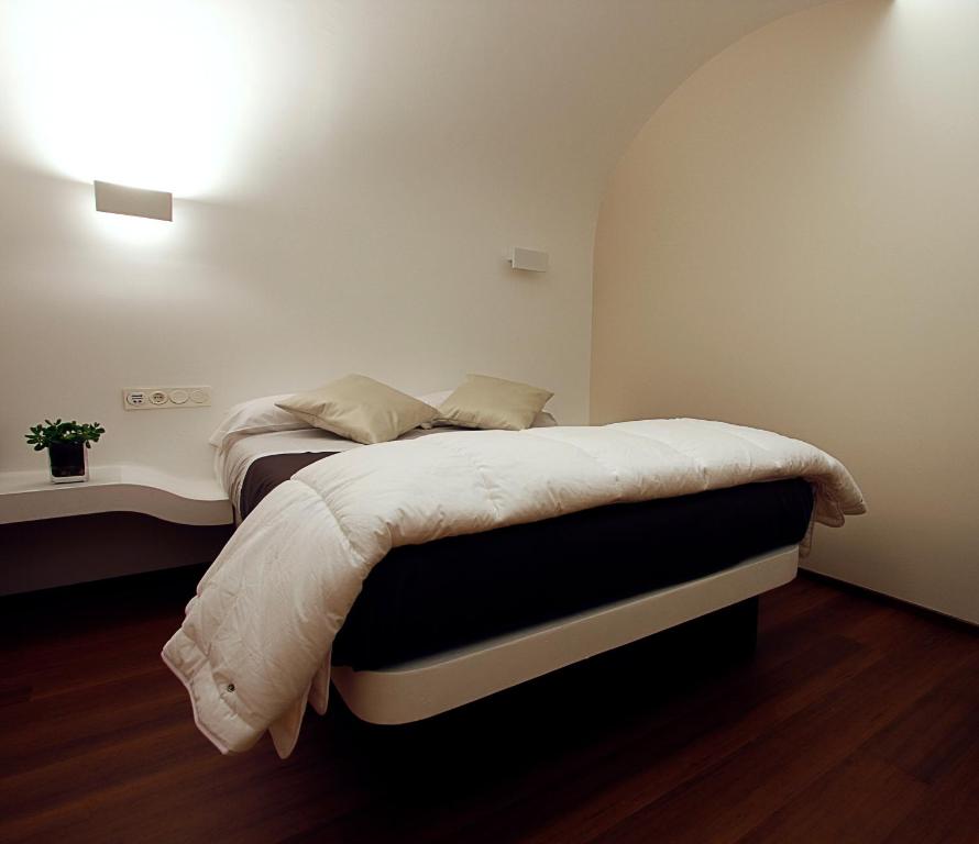 a bedroom with a bed with a white comforter at Pensión Iturriza in Donostia-San Sebastián