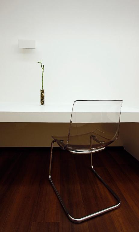 a glass table and a chair in front of a wall at Pensión Iturriza in Donostia-San Sebastián