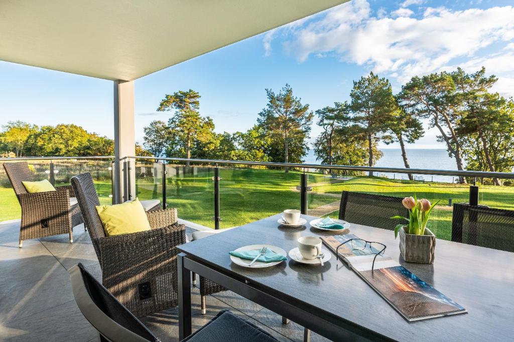 a dining table on a patio with a view of the ocean at Appartement "Dünentraum" - Oase am Haff in Garz