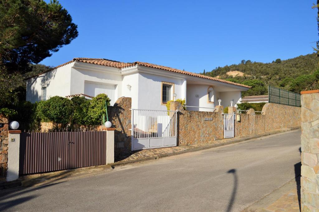 una casa blanca con una valla en una calle en Can Ronia, en Tossa de Mar