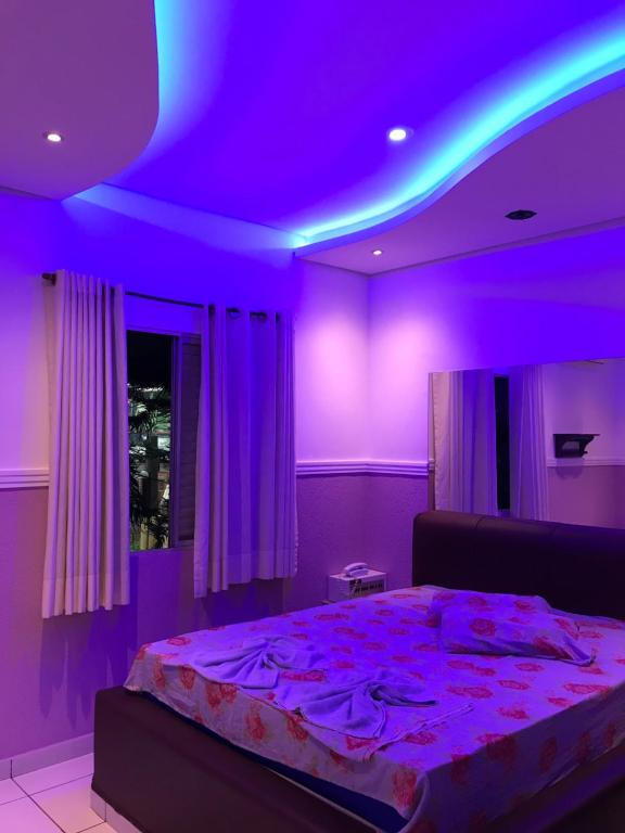 Cette chambre violette comprend un lit et un plafond violet. dans l'établissement Hotel Campo Limpo (Adults Only), à Campo Limpo