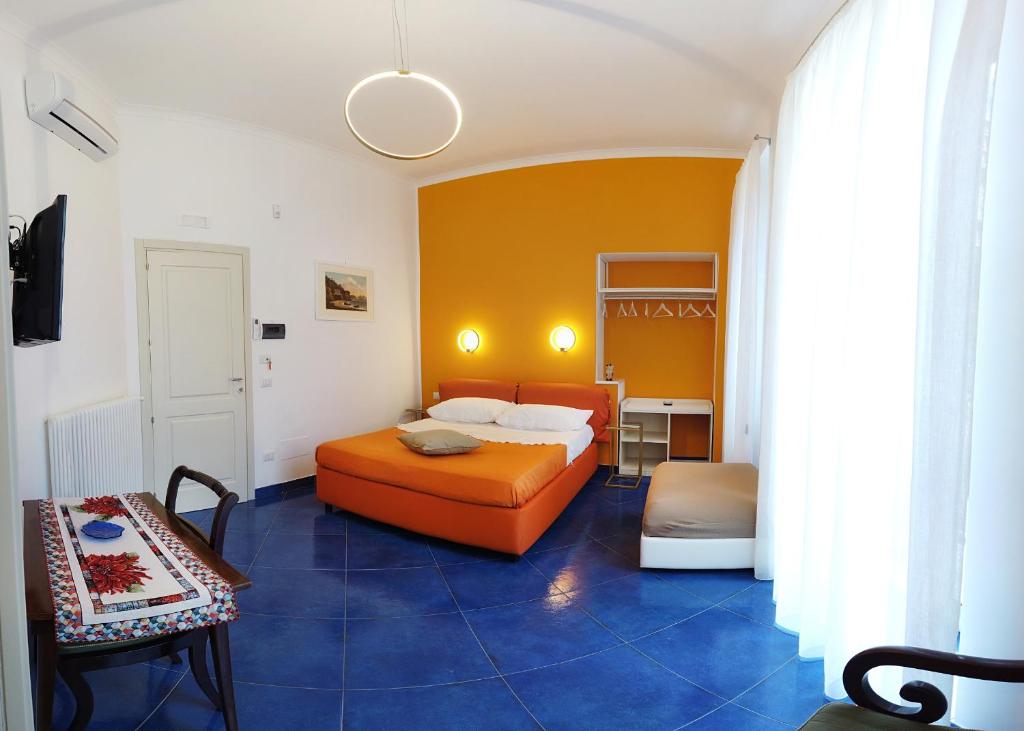 ein Schlafzimmer mit einem orangenen Bett und einem Tisch in der Unterkunft Cannone53 in Neapel