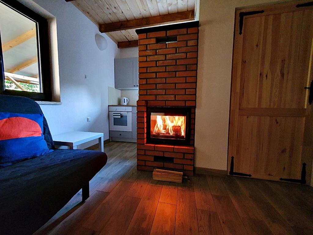 uma sala de estar com lareira de tijolos num quarto em Domki w Nowicy em Nowica