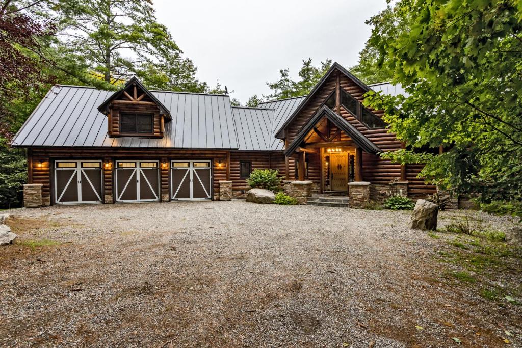 a log home with a large driveway in front of it at Large Luxury Lakefront Cottage Calabogie in Rockland