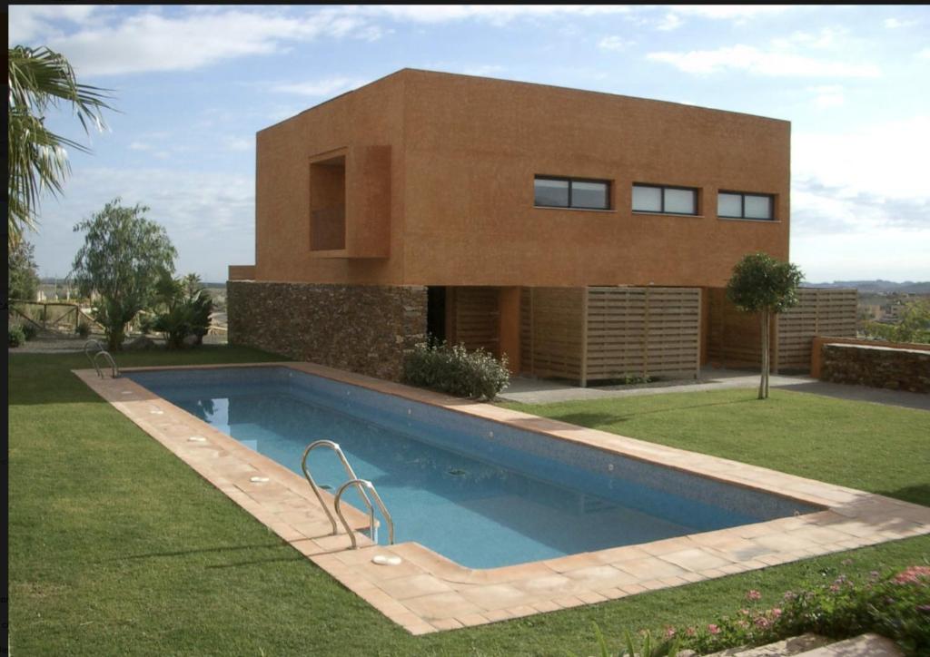 una casa con piscina di fronte a una casa di Preciosa Casa de diseño Valle del Este Golf Resort ideal para familias a Vera