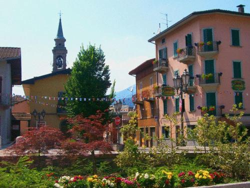 un gruppo di edifici in una città con una torre dell'orologio di Albergo Centrale a Fino del Monte