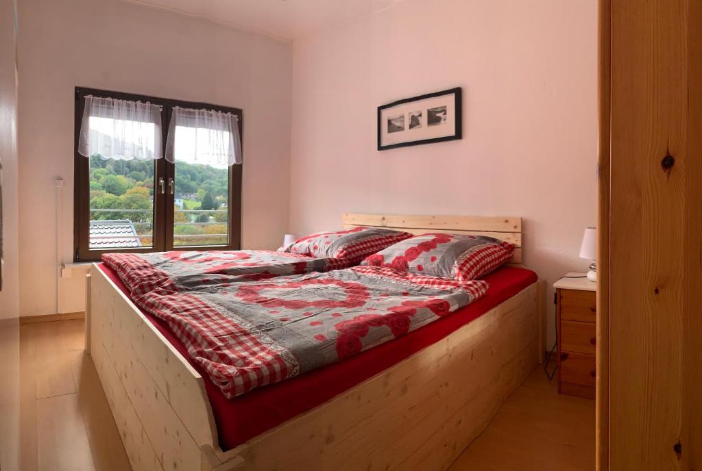 - une chambre avec un lit en bois et une fenêtre dans l'établissement Die Alm, à Heimbach