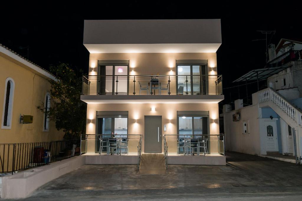 een groot wit gebouw met een balkon in de nacht bij KIPOI APARTMENTS in Zakynthos