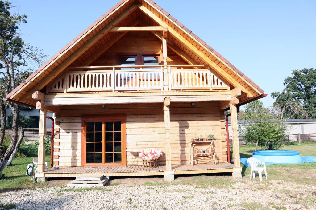 Holiday house with sauna في ريغا: كابينة خشبية مع شرفة وسطح