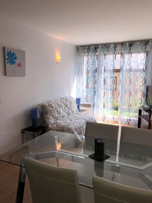 uma sala de estar com uma mesa de vidro e um sofá em ARA 1D em Pas de la Casa