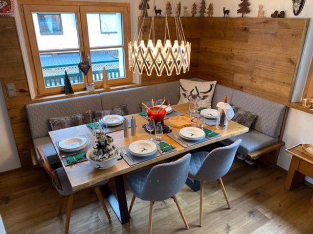 a dining room table with chairs and a table and a table at Alpin Chalet Kern in Klösterle am Arlberg