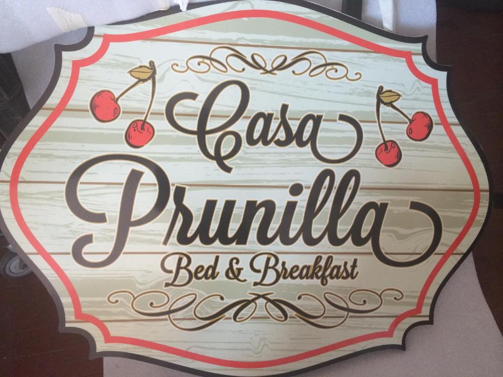 un cartello per un ristorante con sopra le ciliegie di Casa Prunilla a Sarno