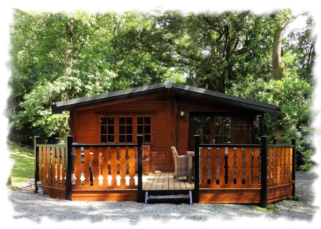 a log cabin with a gate and a deck at Blelham Tarn (Log Cabin) in Ambleside