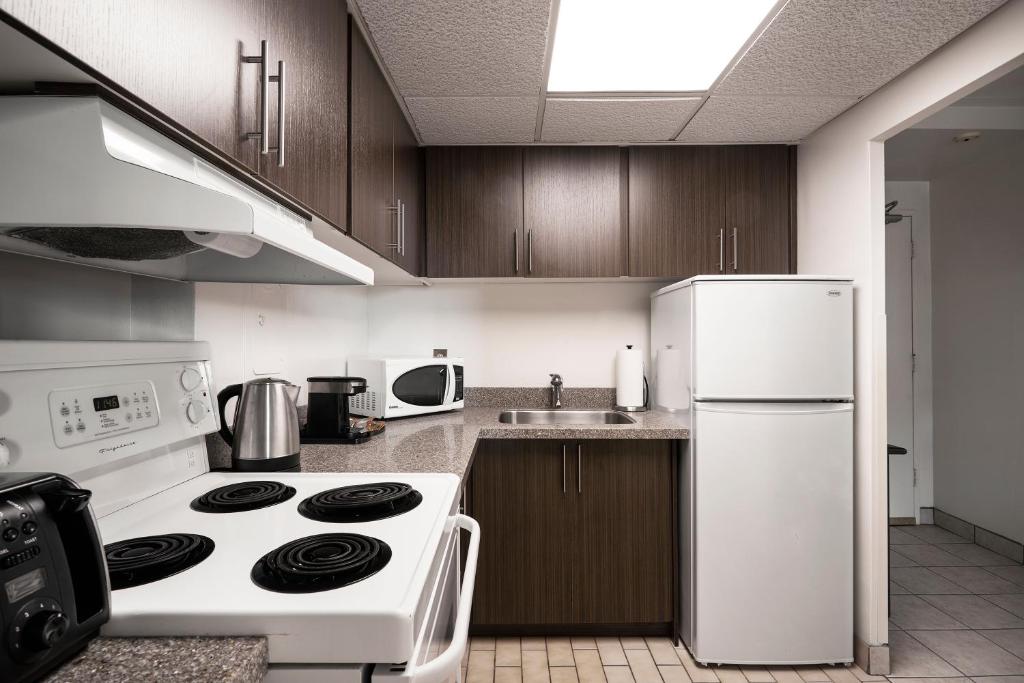 a kitchen with a white stove and a refrigerator at The Business Inn in Ottawa