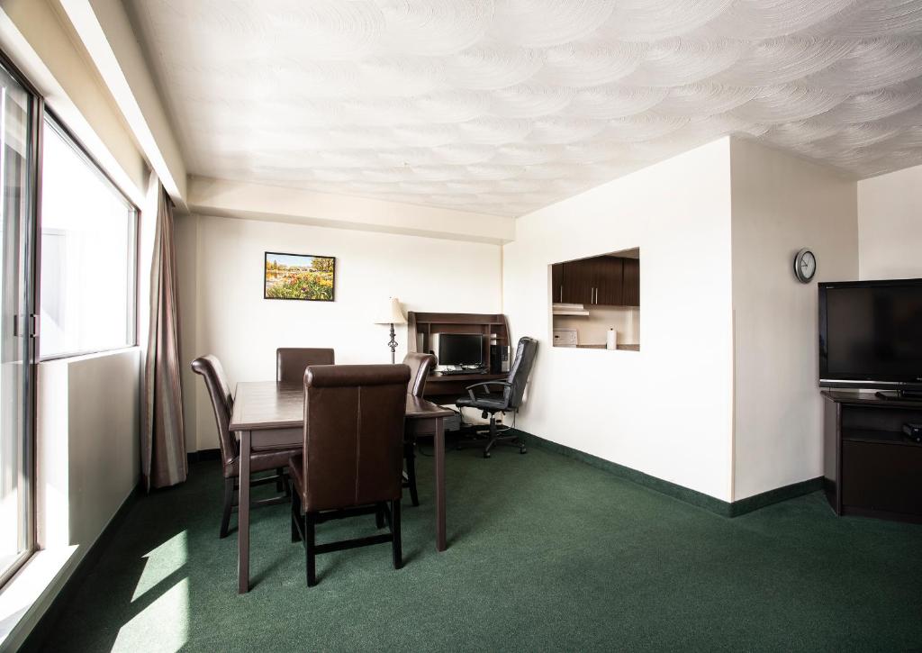 a room with a table and chairs and a television at The Business Inn in Ottawa