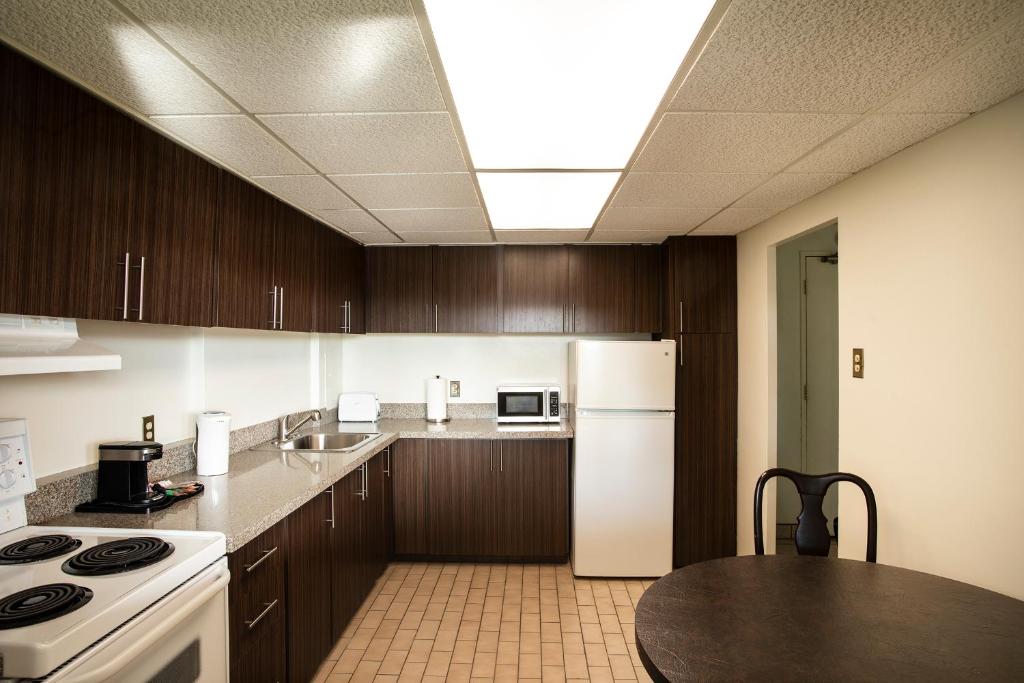 a kitchen with wooden cabinets and a white refrigerator at The Business Inn in Ottawa