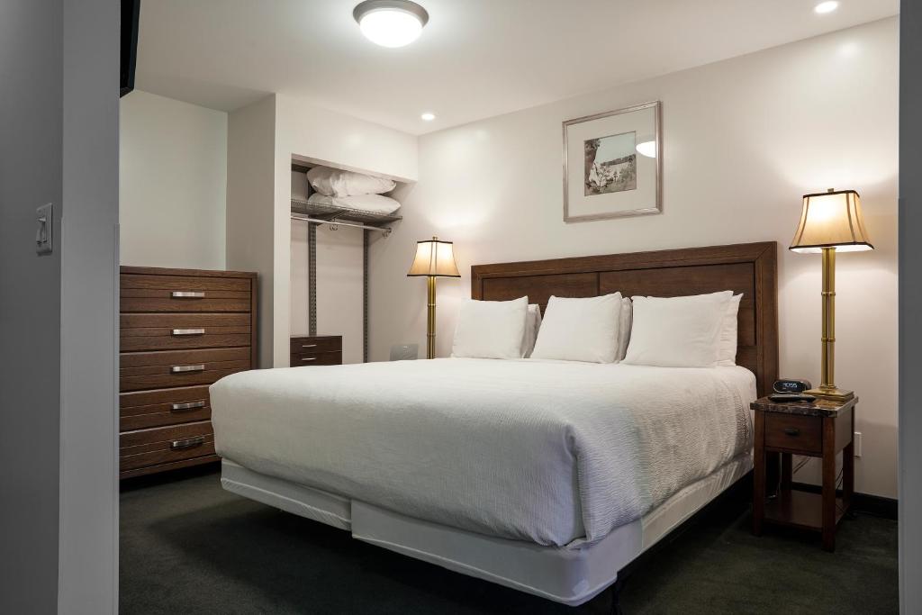 a bedroom with a large white bed and two lamps at The Business Inn in Ottawa
