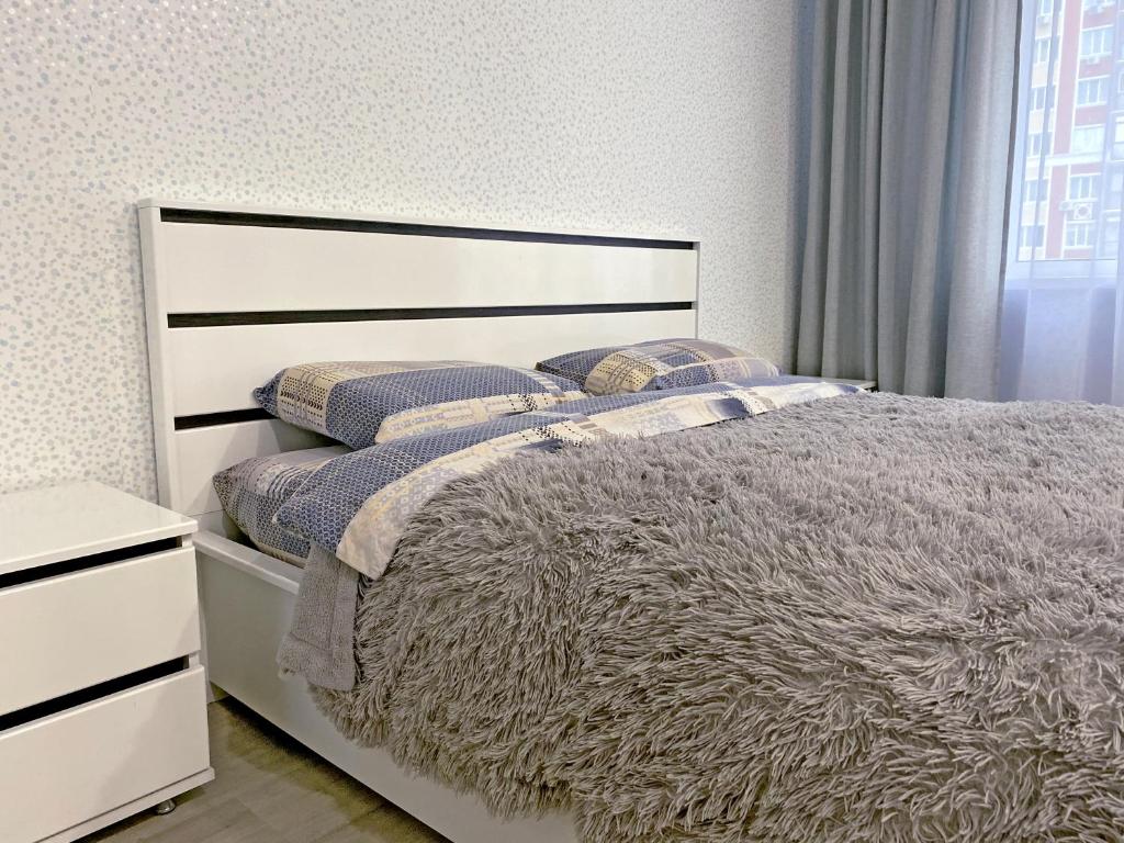sypialnia z białym łóżkiem i oknem w obiekcie Современная студия с отдельной спальней с видом на Versal Park w mieście Irpień