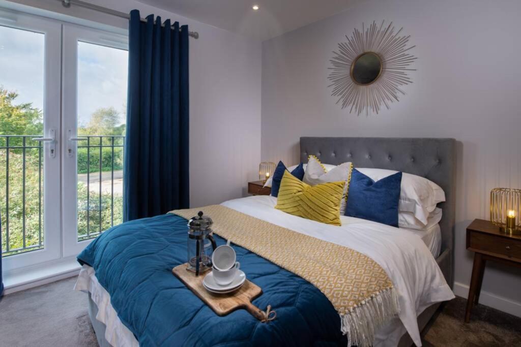 a bedroom with a bed with blue and yellow pillows at Roseland Apartment 4 in Arundel