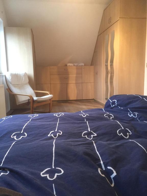uma cama com um cobertor azul com desenhos em Julie's Place em Westerlo