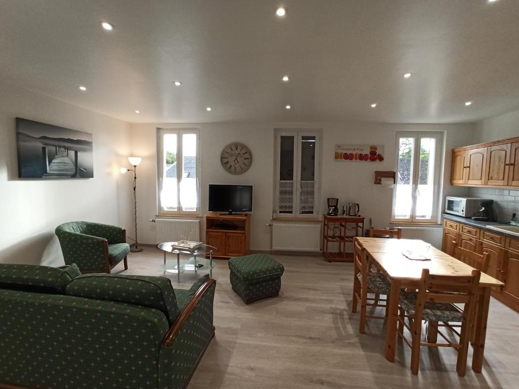 a living room with a couch and a table at Le Nid de la Baie de Somme in Friville-Escarbotin