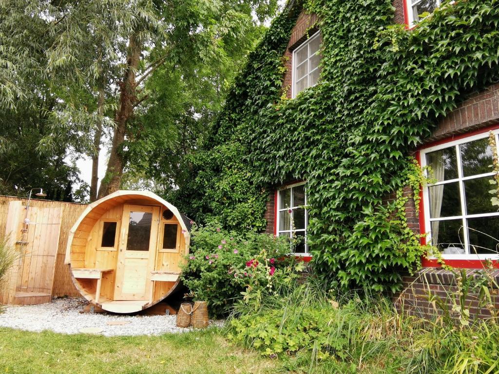 a wooden shed is next to a house at Haus am Deich in Kollmar