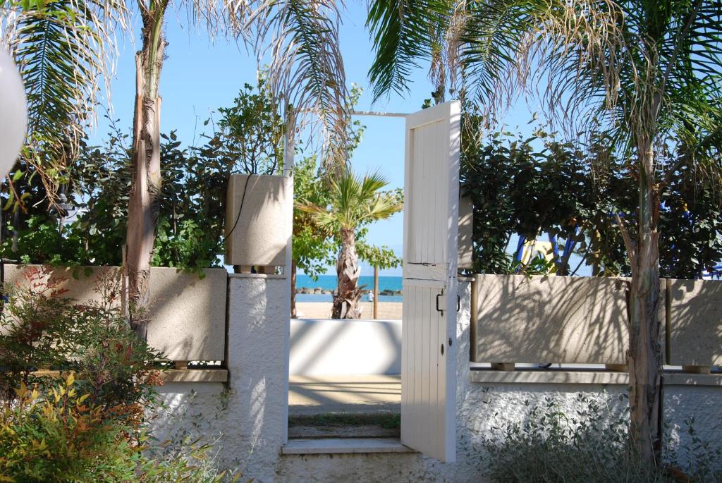 een open poort naar een strand met palmbomen bij Villa Ada in Francavilla al Mare