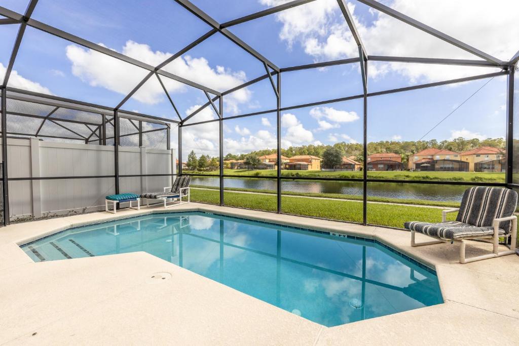 una piscina en una casa de cristal con vistas en Fantastic Lakeview Townhome near Disney en Kissimmee