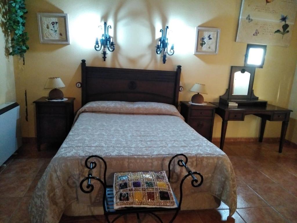 1 dormitorio con 1 cama, 2 mesas y espejo en CASONA de los Peregrinos I, en Cepeda