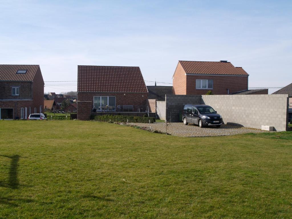 een auto geparkeerd in een tuin voor sommige huizen bij De Jölenberg in Heers