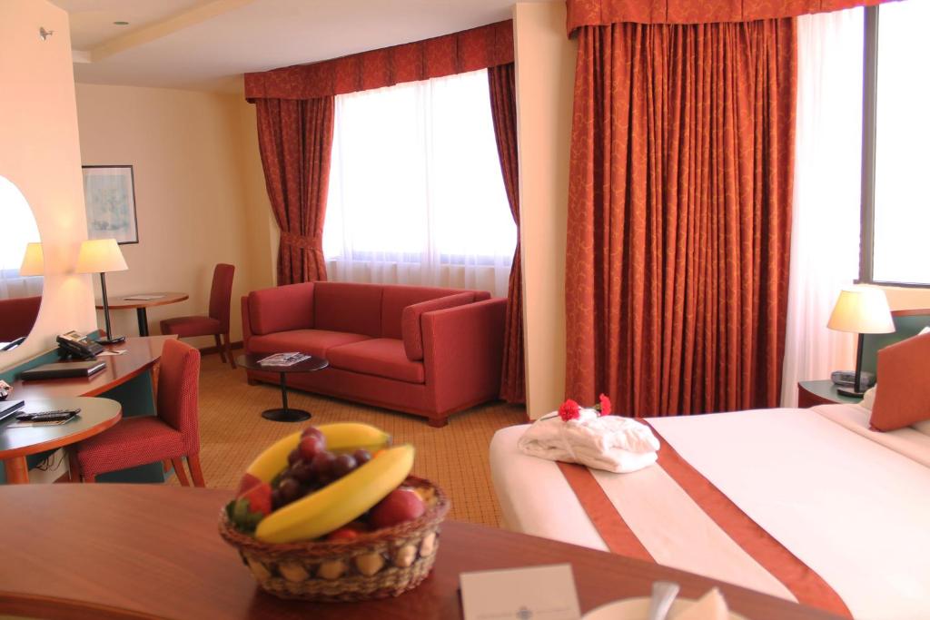 une chambre d'hôtel avec un lit et un bol de fruits sur une table dans l'établissement Al Diar Dana Hotel, à Abu Dhabi