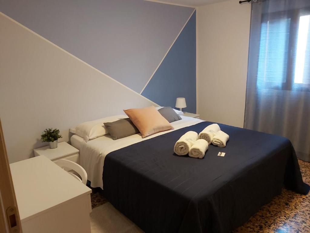 a bedroom with a large bed with towels on it at Veneziacentopercento Apartments & Rooms in Venice