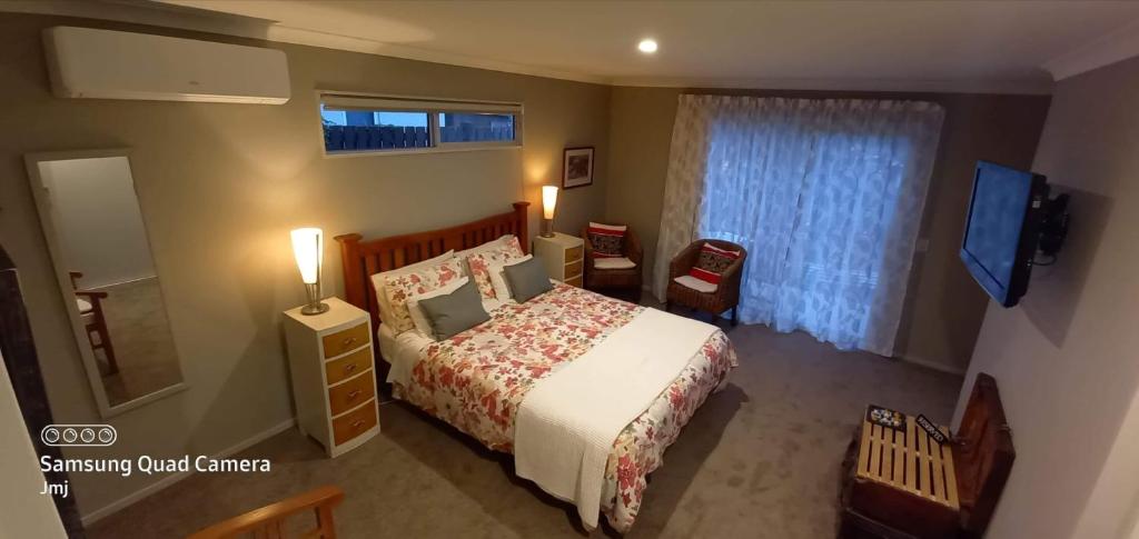 1 dormitorio con cama, ventana y TV en Grampians B&B, en Nelson