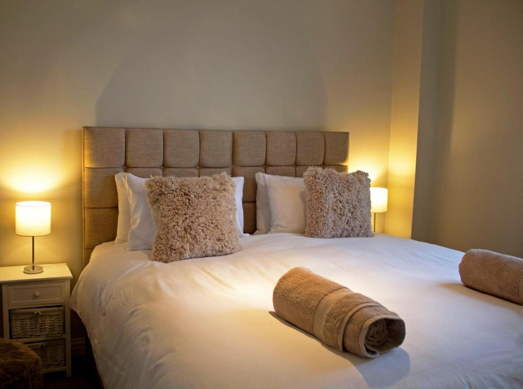 a bedroom with a large white bed with two pillows at The Berwick Inn in Polegate