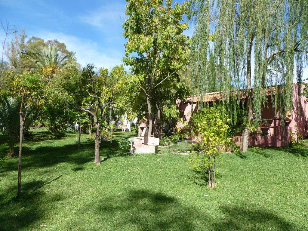 a garden with trees and a building in the background at Eco Moyano Posada in Gaucín