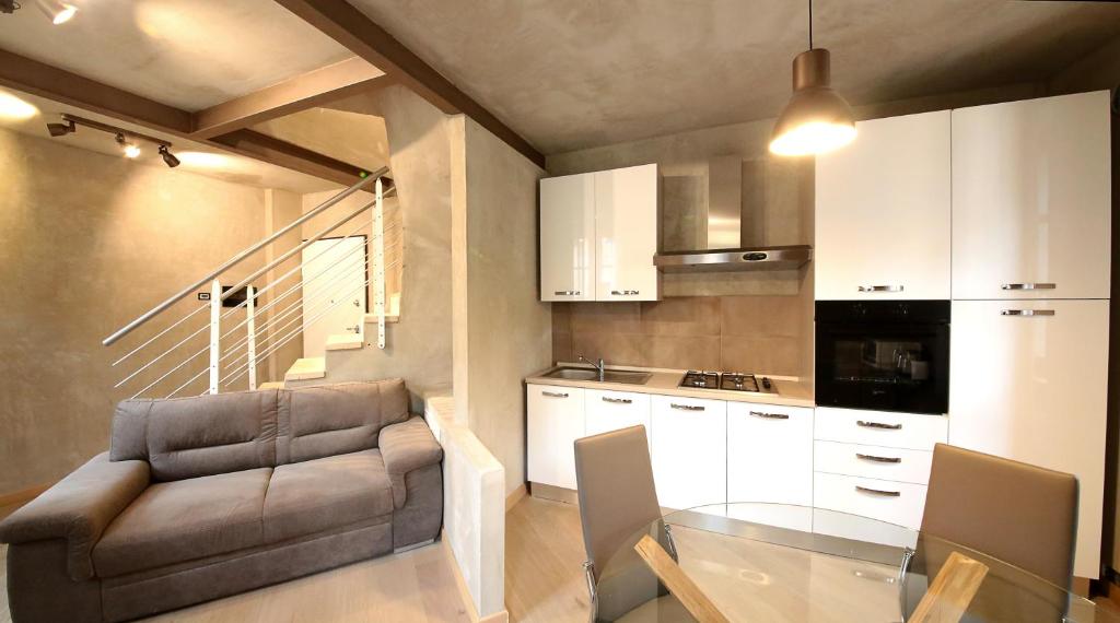 uma cozinha com um sofá e uma mesa num quarto em Vieille maison em Aosta