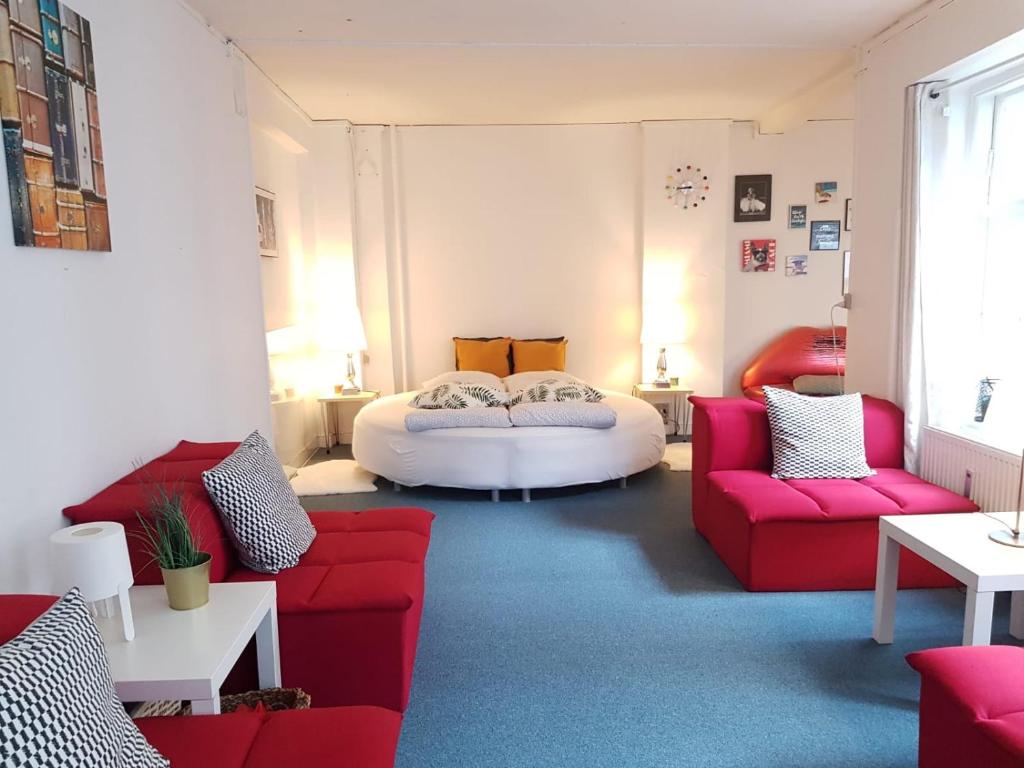 sala de estar con sofá rojo y cama en Cozy Studio Apartment right next to the City Hall en Copenhague